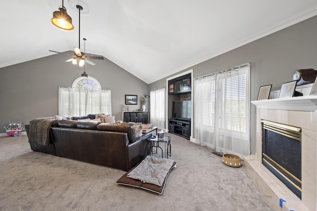 carpeted living room featuring a tile fireplace, lofted ceiling, ceiling fan, and crown molding