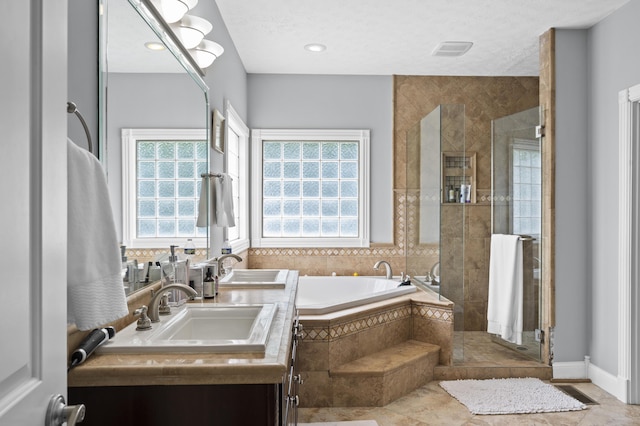 bathroom featuring vanity, independent shower and bath, and a textured ceiling