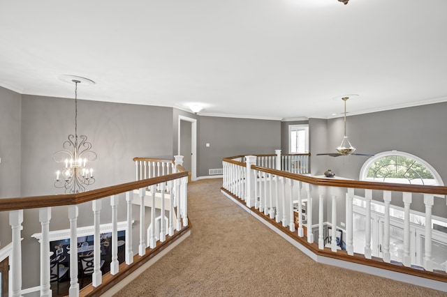 hallway featuring crown molding, carpet flooring, and a chandelier