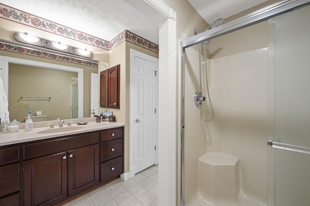 bathroom with vanity, a shower with door, and a textured ceiling