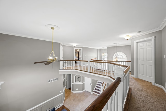 hallway with crown molding, light colored carpet, and a chandelier