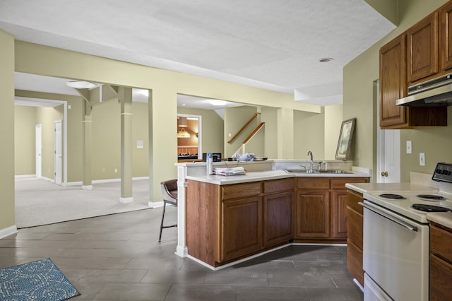 kitchen featuring a breakfast bar, white electric range, sink, kitchen peninsula, and a textured ceiling