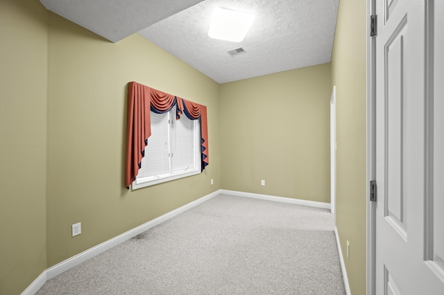 carpeted empty room with a textured ceiling