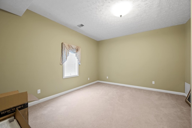 carpeted empty room featuring a textured ceiling