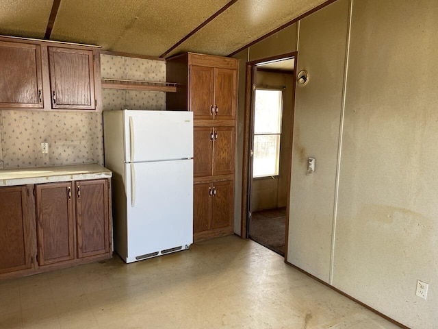 kitchen with white fridge and lofted ceiling