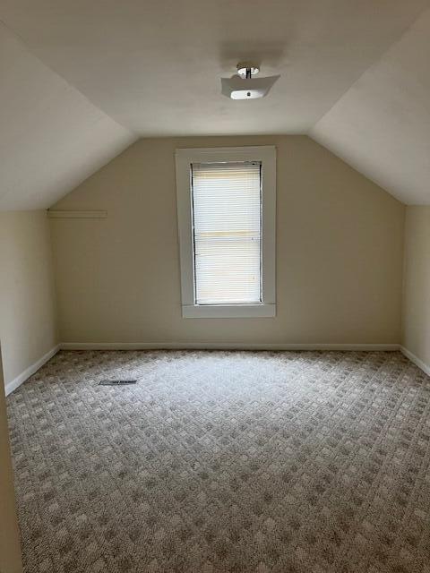 bonus room with carpet floors and vaulted ceiling