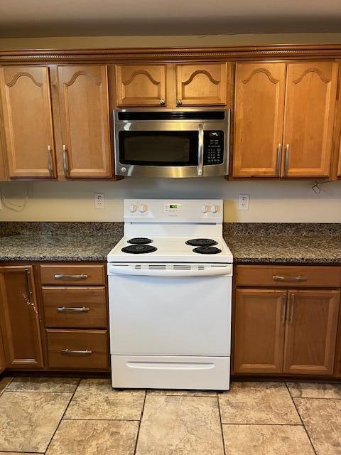 kitchen with dark stone countertops and electric range