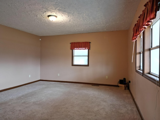 carpeted spare room featuring a textured ceiling