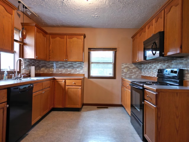 kitchen with sink, backsplash, black appliances, and a textured ceiling