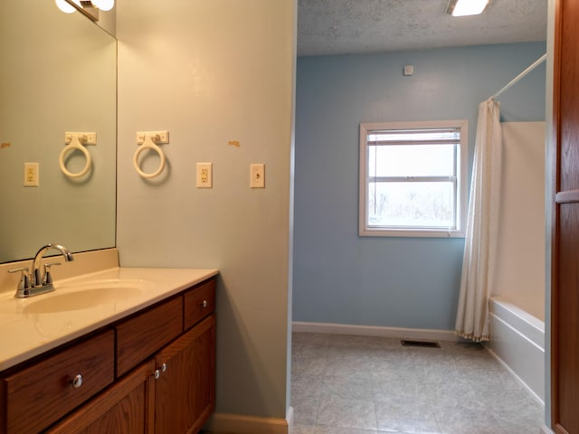 bathroom featuring vanity, shower / tub combo, and a textured ceiling