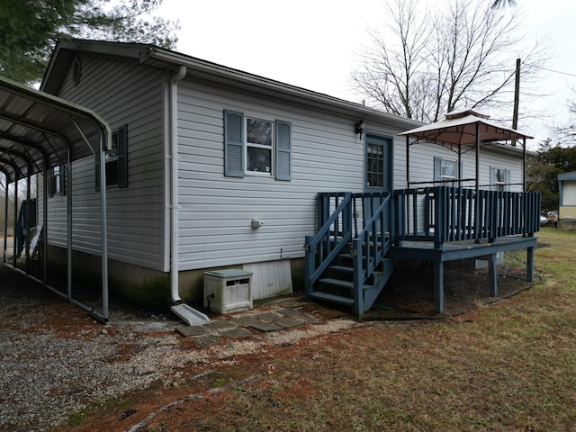 rear view of property featuring a carport and a deck