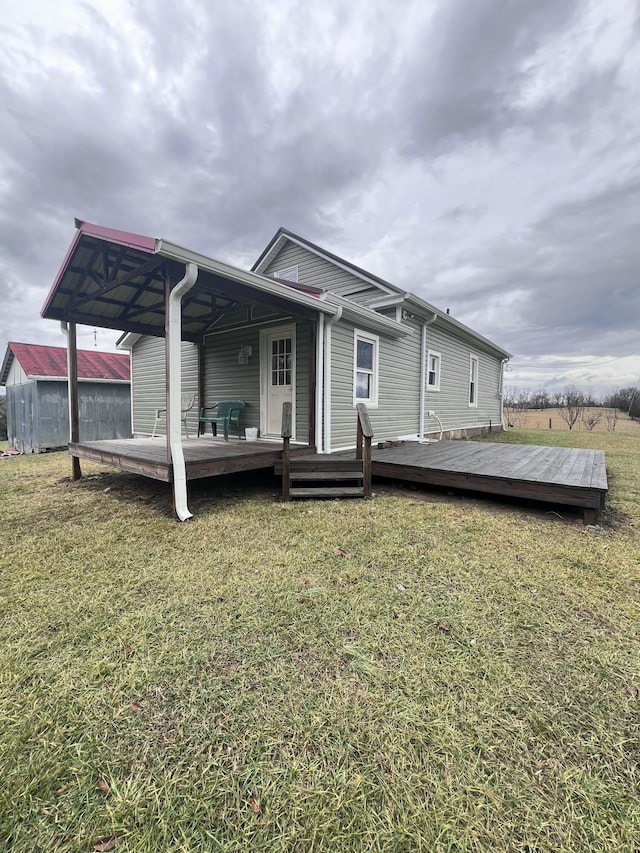 rear view of house with a deck and a lawn