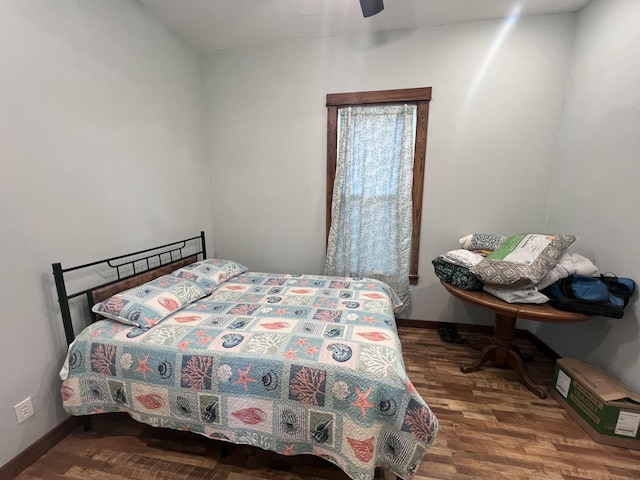 bedroom with dark hardwood / wood-style floors and ceiling fan