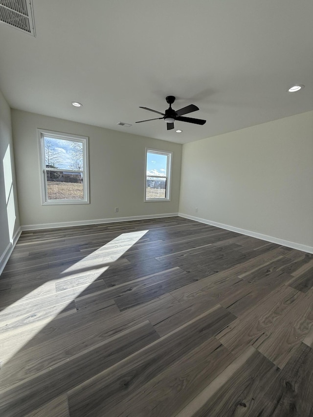 spare room featuring dark wood-type flooring and ceiling fan