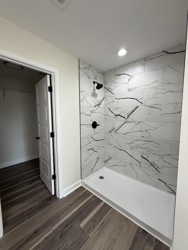 bathroom featuring hardwood / wood-style flooring and tiled shower