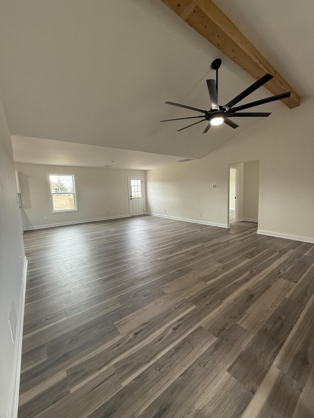 empty room with dark hardwood / wood-style flooring, ceiling fan, a wealth of natural light, and beamed ceiling