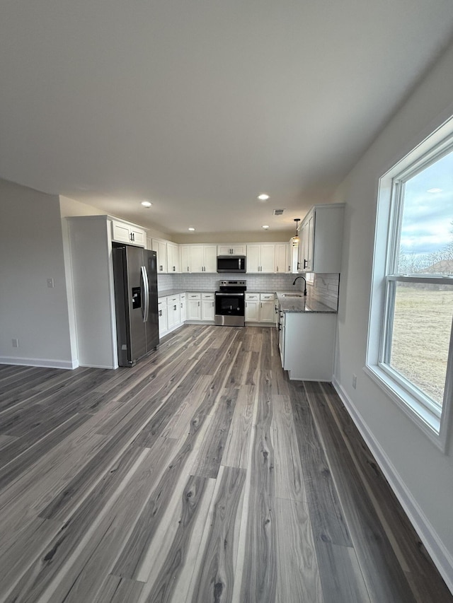 kitchen with tasteful backsplash, sink, white cabinets, dark hardwood / wood-style flooring, and stainless steel appliances