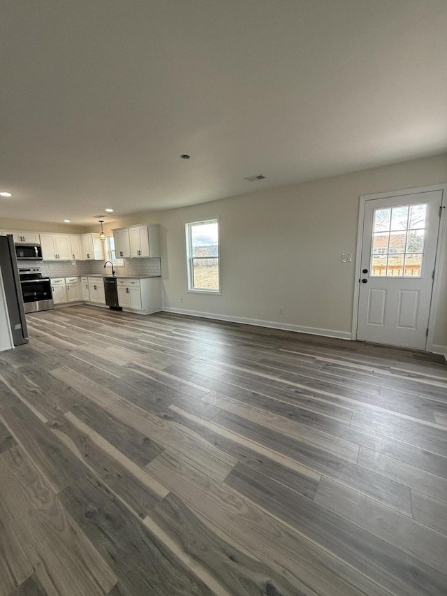 unfurnished living room with dark wood-type flooring