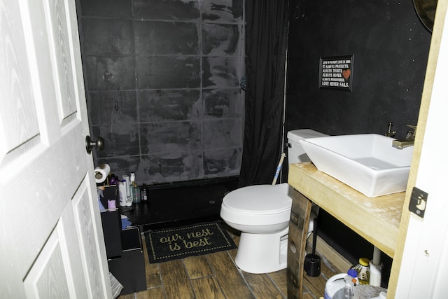 bathroom with wood-type flooring, sink, toilet, and a shower with curtain