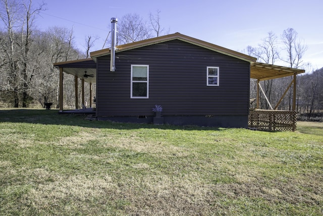 view of home's exterior featuring ceiling fan and a lawn