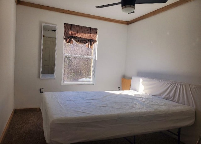 carpeted bedroom with ceiling fan and ornamental molding