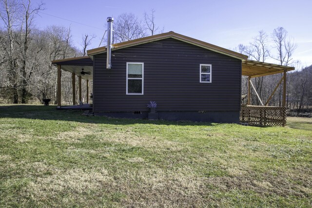 view of home's exterior with a yard and ceiling fan