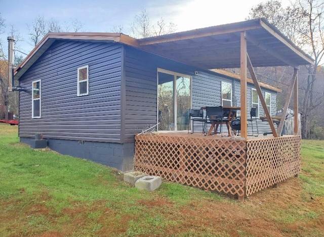 rear view of property with a yard and a deck