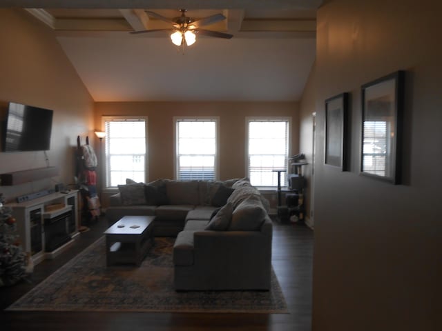 living room featuring vaulted ceiling with beams, ceiling fan, dark hardwood / wood-style flooring, and a wealth of natural light