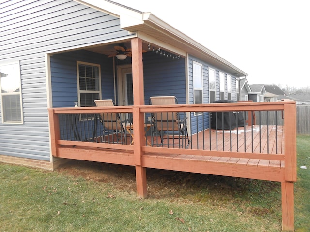 wooden terrace with ceiling fan and a lawn