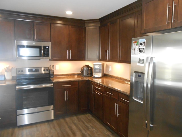 kitchen featuring stainless steel appliances, dark hardwood / wood-style floors, and dark brown cabinets