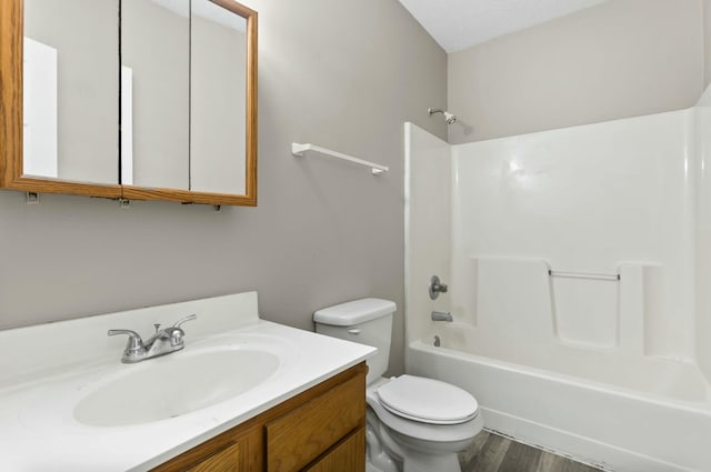 full bathroom with hardwood / wood-style flooring, vanity, bathtub / shower combination, and toilet