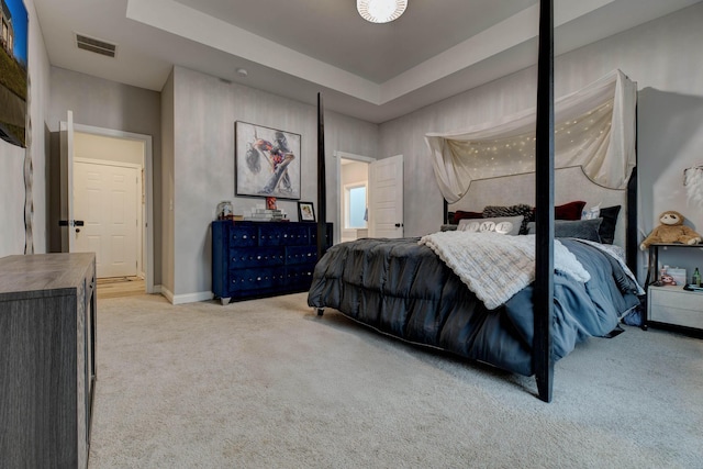 carpeted bedroom with a raised ceiling