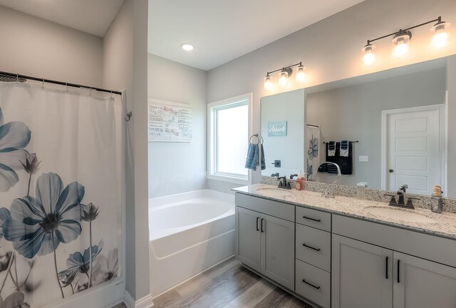 bathroom with curtained shower, double vanity, wood finished floors, a sink, and a garden tub