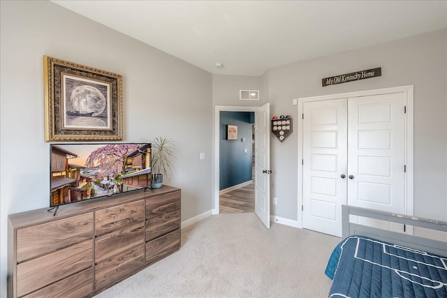 bedroom featuring a closet, carpet flooring, baseboards, and visible vents