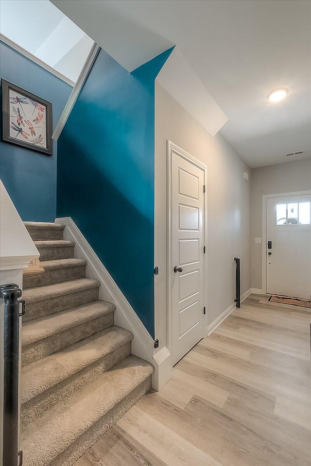 stairs with baseboards and wood finished floors