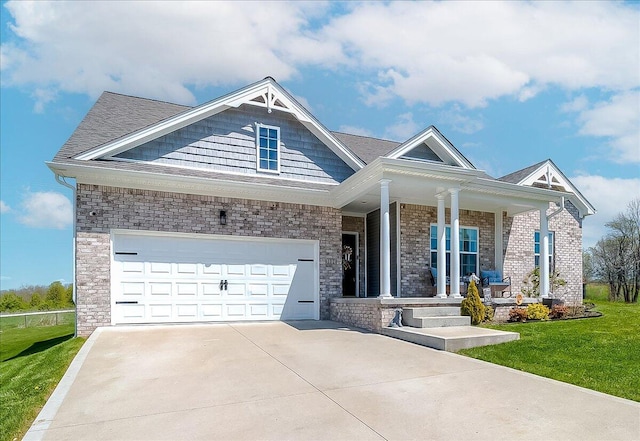 craftsman-style house with a front lawn, driveway, a porch, brick siding, and a shingled roof