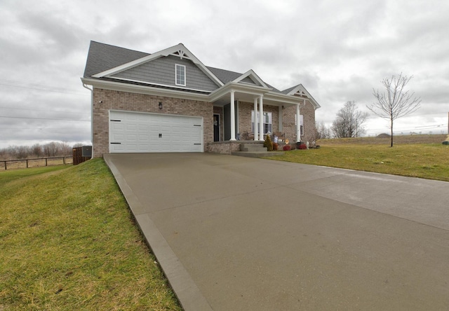 view of front of home with brick siding, a porch, concrete driveway, a front yard, and fence