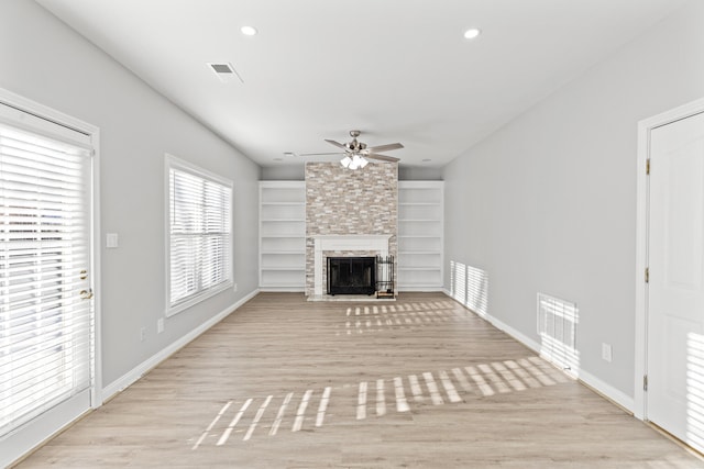 unfurnished living room featuring ceiling fan, light wood-type flooring, and a fireplace