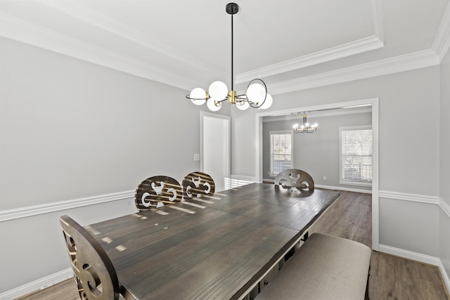 dining space with an inviting chandelier, hardwood / wood-style floors, and ornamental molding