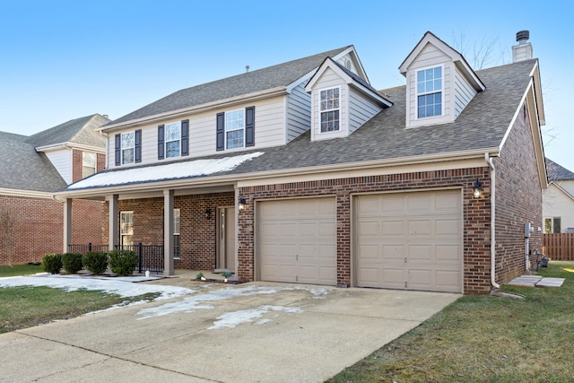 view of front of house featuring a garage, covered porch, and a front yard