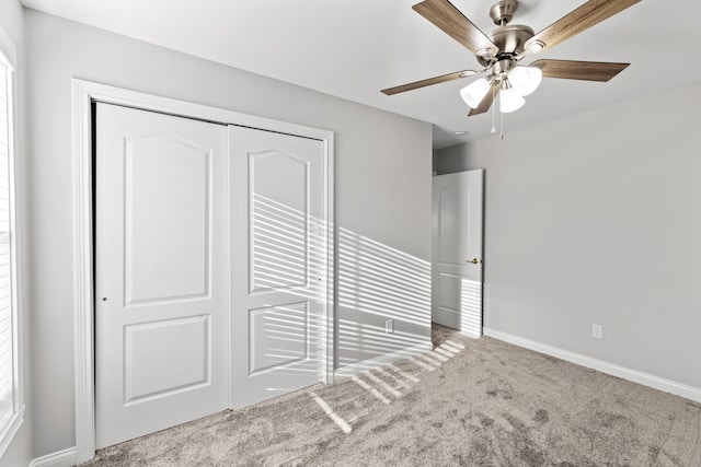 unfurnished bedroom with carpet, ceiling fan, and a closet