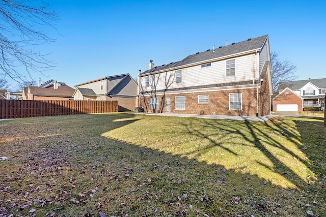 rear view of property with a garage and a lawn