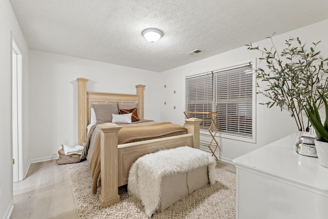 bedroom with light hardwood / wood-style flooring and a textured ceiling