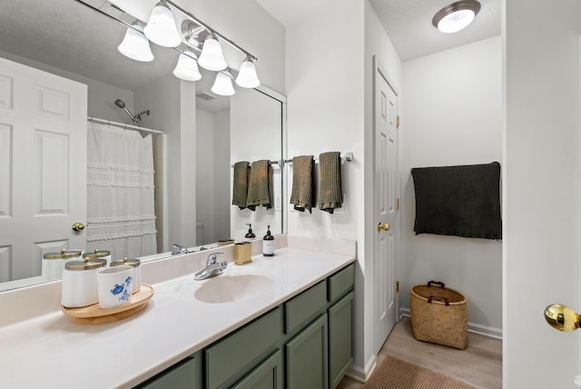 bathroom with vanity, hardwood / wood-style floors, and a textured ceiling