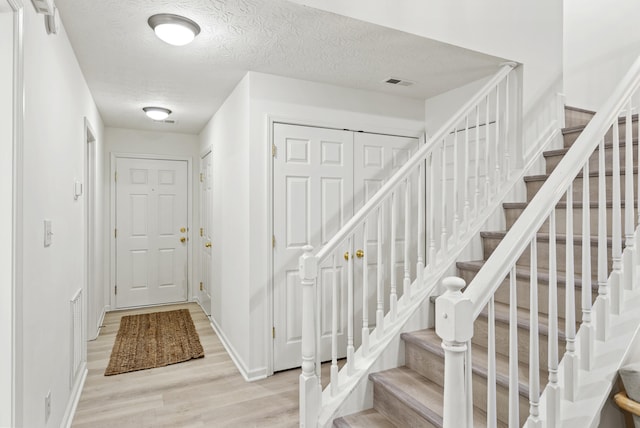 foyer featuring a textured ceiling and light wood-type flooring