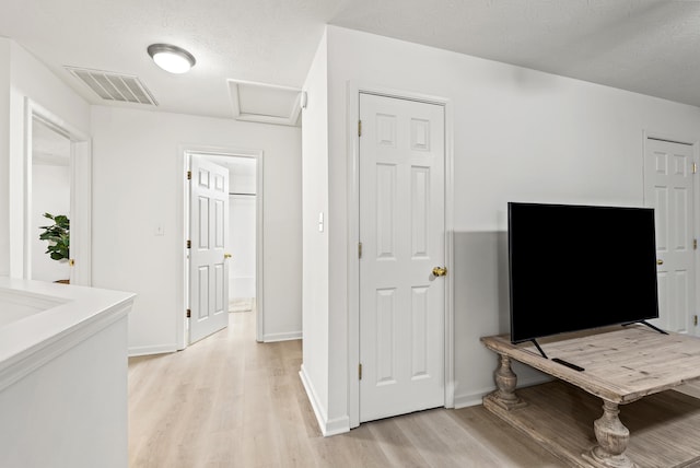 interior space with a textured ceiling and light wood-type flooring