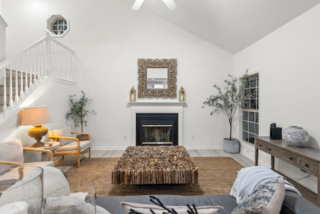 living room featuring hardwood / wood-style floors, high vaulted ceiling, and ceiling fan