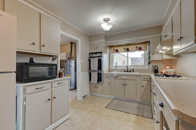 kitchen with sink, ornamental molding, black appliances, and water heater