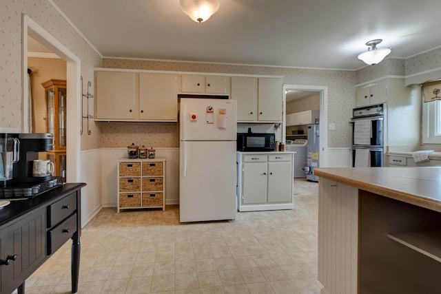 kitchen with crown molding, gas water heater, black appliances, and cream cabinetry