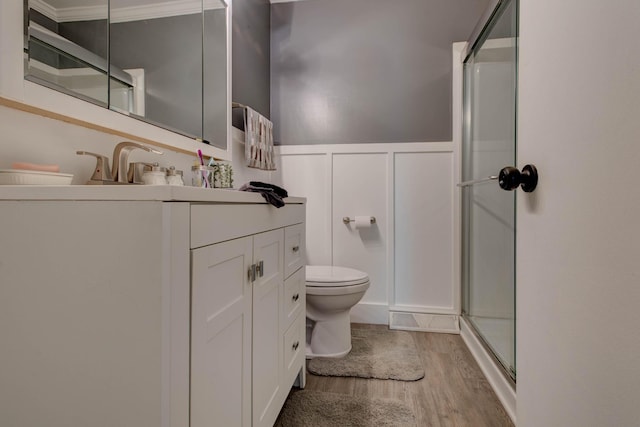 bathroom featuring vanity, an enclosed shower, wood-type flooring, and toilet